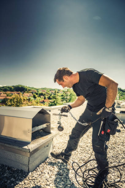 Chimney sweeper cleaning a chimney on top of the roof